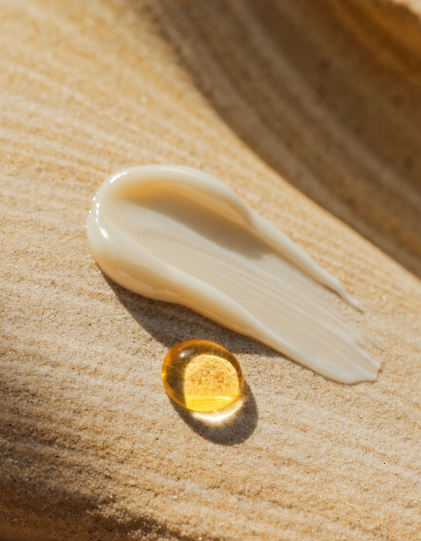 Cream and facial oil texture on sandstone